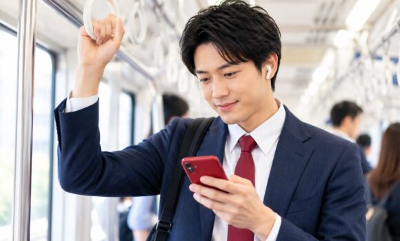 通勤電車内でスマートフォンを使って中国語を学習する会社員