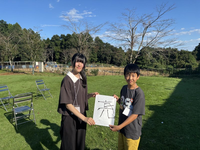 書き上がった漢字を掲げる参加者