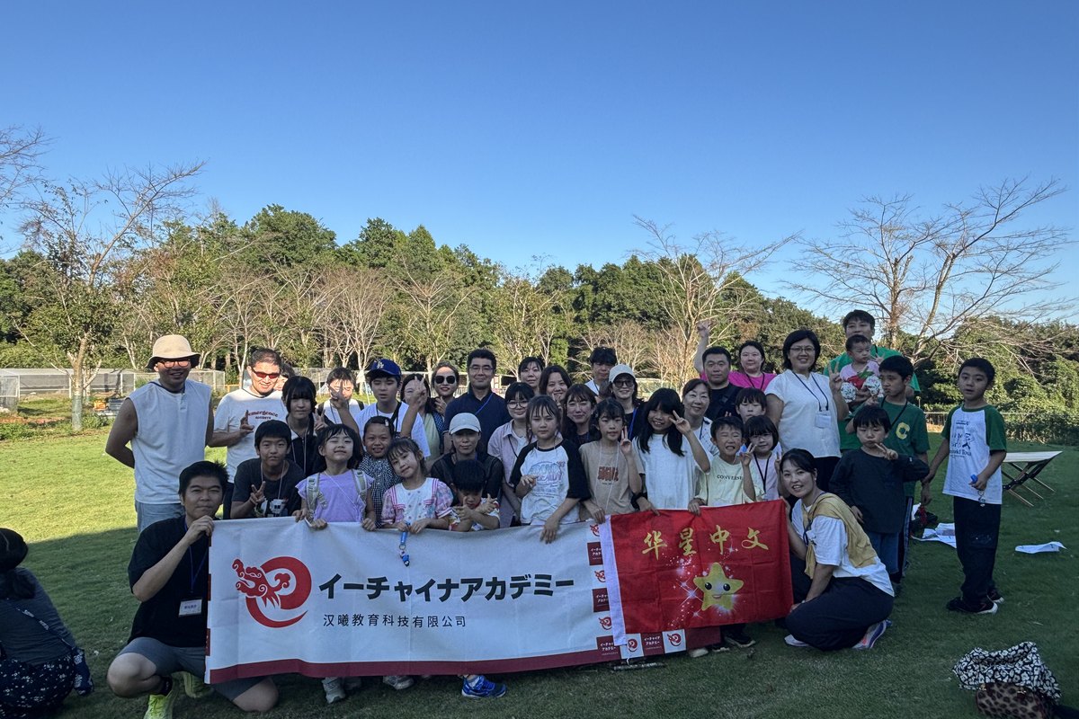 清水エコファームでの集合写真。イーチャイナアカデミーと華星中国語のバナーを持つ参加者