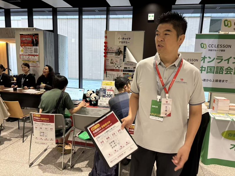 来場者に中国語EXを説明するスタッフ