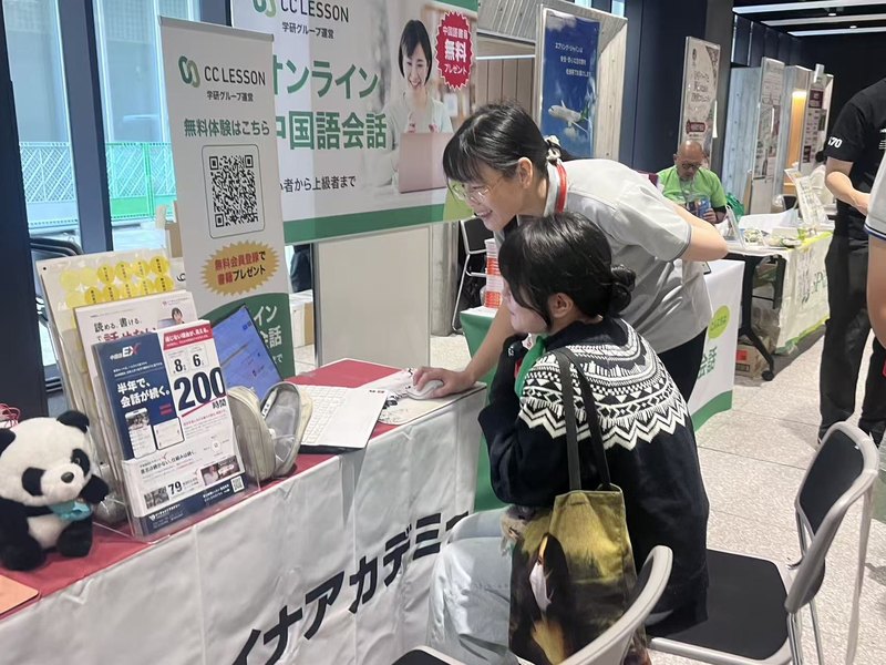 ブースで資料を見ながら相談する来場者